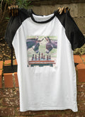 White raglan T-shirt with black sleeves printed with two donkeys playing chess