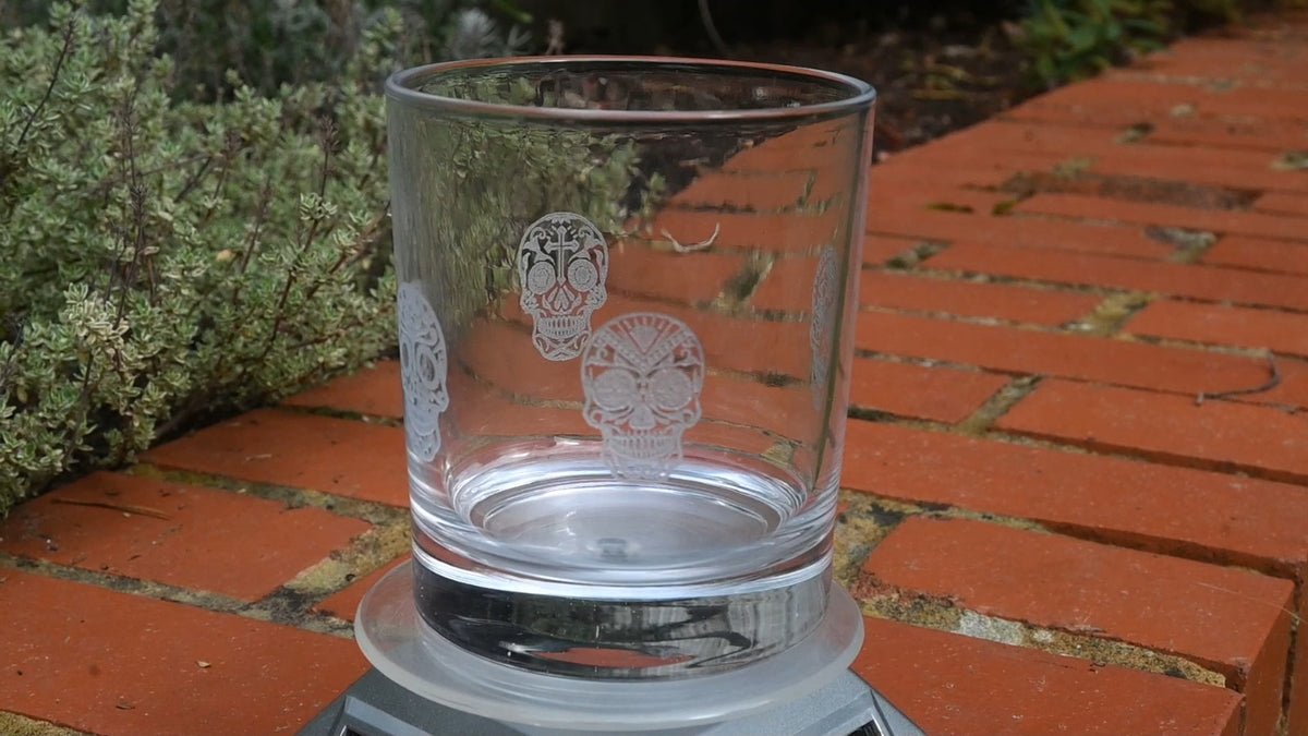 Four sugar skulls engraved around a glass tumbler for Day of the Dead – view 2