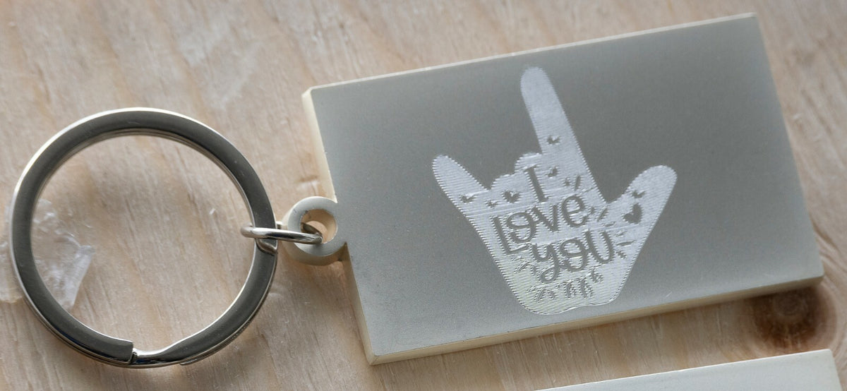 I love you hand sign engraved on a keyring with hearts